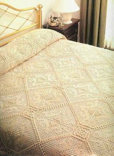 an image of a bedroom setting with a bed and nightstand in the foreground, there is a white crocheted bedspread on top