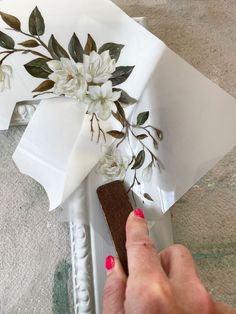 someone is cutting paper with scissors and some flowers on the edge of it to make a flower arrangement