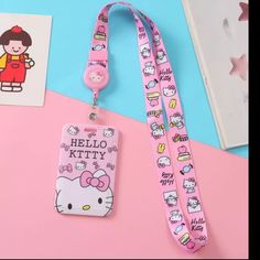 a pink lanyard with hello kitty on it and an id card holder attached to the lanyard