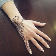 a woman's hand with a henna tattoo on it