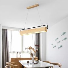 a dining room table with two chairs and a light fixture hanging from it's ceiling