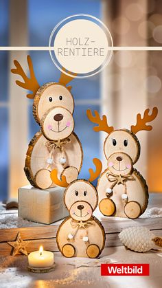 three wooden reindeer figurines sitting on top of a table next to a lit candle