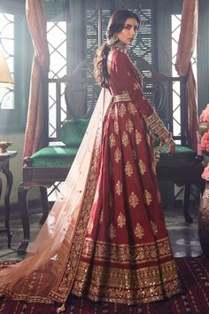 a woman in a red and gold bridal gown