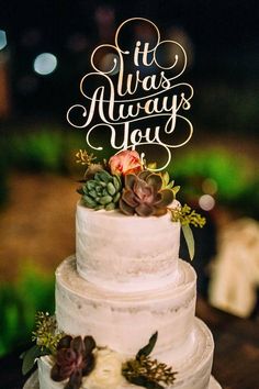 a white wedding cake with succulents and the words it was always you