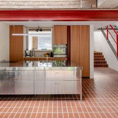 a kitchen with stainless steel appliances and red stairs