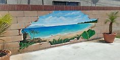 a mural on the side of a brick wall depicting a tropical beach and palm trees