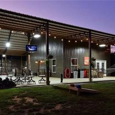 an outside view of a building with lights on the roof and lawn chairs in front