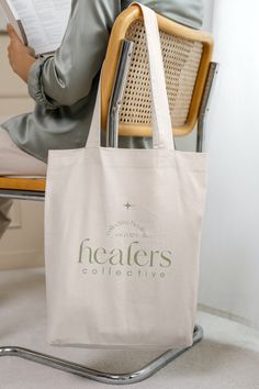 "Introducing the Healers Collective 100% cotton tote bag - stylish, eco-friendly, and perfect for your everyday needs. With a sleek design featuring our brand name, this durable bag is perfect for carrying your essentials while making a statement. Order yours today! A 100% cotton tote bag is the champion of durability, sustainability, and style.  .: Material: 6 oz./yd², 100% natural cotton canvas fabric .: One size: 15\" x 16\" (38.1cm x 40.6cm) .: Convenient self-fabric handles include also care instructions: machine wash in sensitive with cold water .: Hand wash with cold water" Eco-friendly Recyclable Cotton Shoulder Bag, Rectangular Cotton Shoulder Bag With Recyclable Material, Recyclable Cotton Bag For Daily Use, Daily Use Tote Bag With Branding, Everyday Branded Tote Canvas Bag, Eco-friendly Everyday Canvas Bag With Branding, Branded Tote Canvas Bag For Everyday, Branded Everyday Tote Canvas Bag, Eco-friendly Canvas Bag For Daily Use With Branding