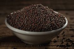 a white bowl filled with seeds on top of a wooden table