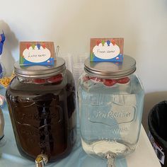 there are three mason jars on the table with labels for each jar and one is filled with liquid