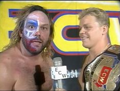 two men standing next to each other with face paint on their faces and one holding a microphone