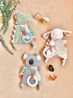 three stuffed animals are sitting next to each other on a table with flowers and leaves