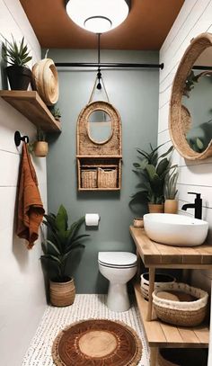 a bathroom that has some plants on the wall and a toilet in it with two mirrors above