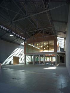 the inside of an empty building with lots of light coming in from the windows and doors