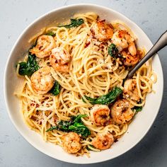 a white bowl filled with pasta and shrimp