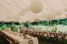 tables and chairs are set up under white paper lanterns