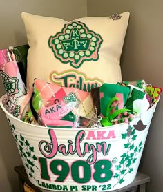 a large white bucket filled with candy and candies next to a pillow on top of a table