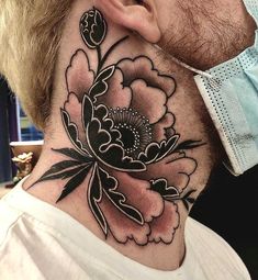 a man's neck with a flower tattoo on it