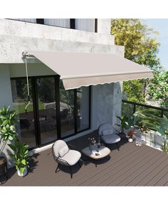 an outdoor patio with chairs and tables under a white awning on the side of a building