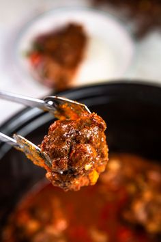 a close up of a fork with food in it