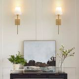 a living room scene with focus on the table and wall sconces above it