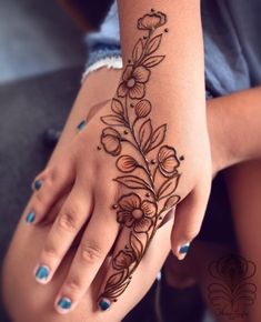 a woman's hand with a flower tattoo on it