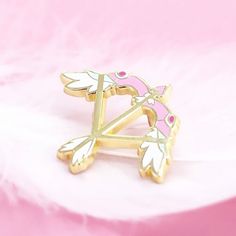 a pink and gold brooch with leaves on it