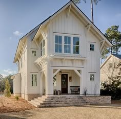 a large white house sitting on top of a dirt field