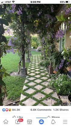 the walkway is lined with purple flowers and greenery