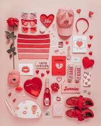 the contents of a valentine's day box laid out on a pink surface