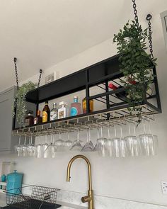 a kitchen sink filled with lots of wine glasses and bottles on top of a shelf