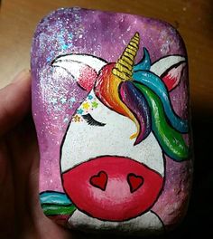 a painted rock with a unicorn face on it