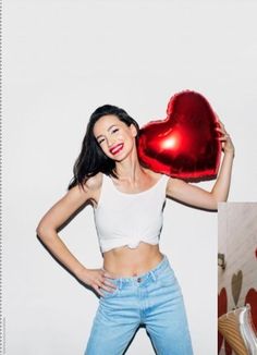 a woman holding a heart shaped balloon in front of her face and posing for the camera