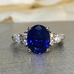 Oval Blue Sapphire Engagement Ring 14K Solid White Gold , Unique Vintage Oval Cluster Ring For Women , Blue Sapphire Engagement Rings #7213 #EngagementRings #UniqueRing #EngagementRing #VintageRing #BridalRing #SapphireRing #14kSolidGold #AnniversaryRing #ForWomen #OvalClusterRing Lab Created Blue Sapphire Ring, Blue Sapphire With Diamonds Ring, Lab Grown Sapphire Engagement Ring, Engagement Rings With Blue Stones, Blue Sapphire Engagement Ring Vintage, Saffire Engagement Rings, Blue Sapphire Rings Engagement, Safire Rings, Vintage Sapphire Engagement Rings