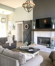 a living room filled with furniture and a flat screen tv mounted on the wall above a fireplace