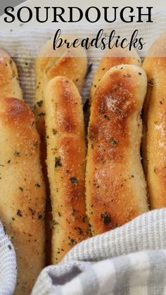 breadsticks with herbs and seasoning on them are in a basket, ready to be eaten