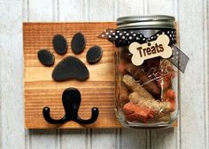 a mason jar filled with dog treats next to a cat's paw magnet on a wooden board