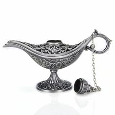 an ornate silver bowl with a chain hanging from it's side and a cup in the middle