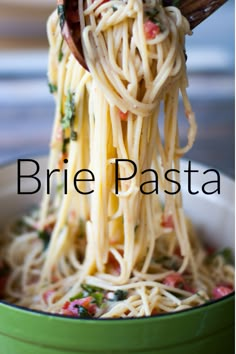 a close up of spaghetti being lifted from a green bowl with the words brie pasta on it