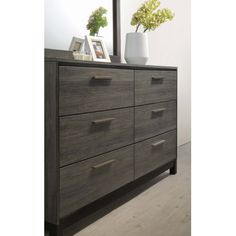 a dresser with two vases on top and a mirror above it in a room