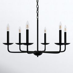 a black chandelier with five candles hanging from it