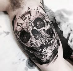 a man's arm with a clock and skull tattoo on the left side of his arm