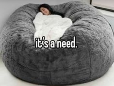 a woman laying in a bean bag chair with the words it's a need