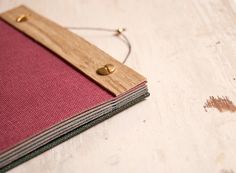 a book with a wooden cover sitting on top of a white table next to a pair of scissors