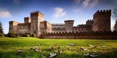 an old castle sitting on top of a lush green field