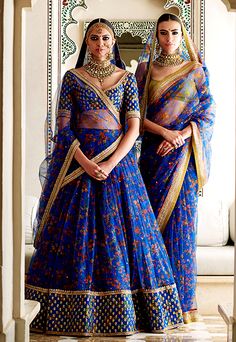 two women in blue dresses standing next to each other