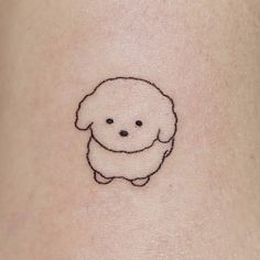 a small black and white dog tattoo on the stomach