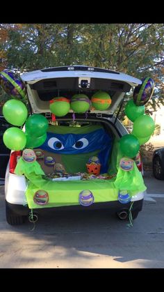 the trunk of a car decorated with balloons and decorations for an inside look at monsters