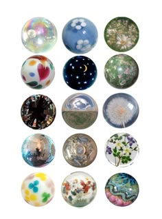 nine glass balls with different designs and colors in the middle one has a dandelion on it