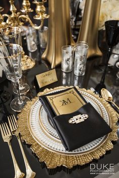 a black and gold table setting with silverware